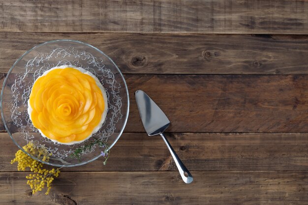 Postre de tres leches con gelatina decorado con melocotones sobre una base de madera. Copie el espacio. Vista superior.