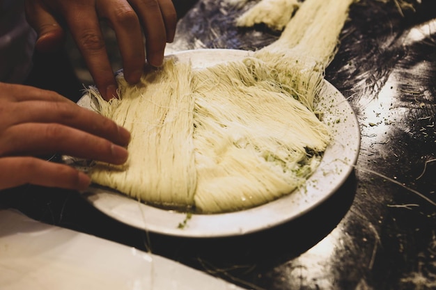 Postre turco kunefe, kunafa, kadayif con polvo de pistacho y queso caliente comido un dulce