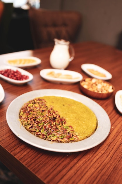 Postre turco kunefe kunafa kadayif con polvo de pistacho y queso caliente comido un dulce