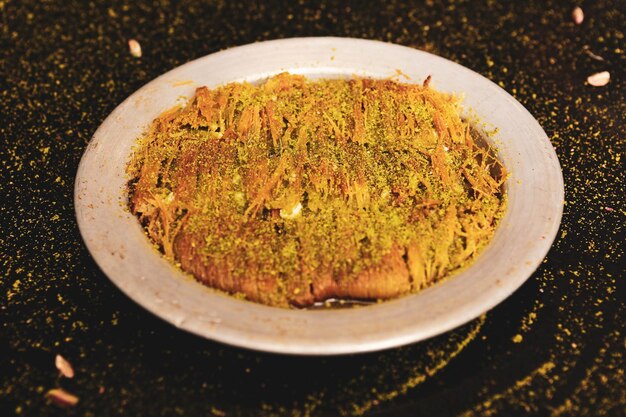 Postre turco kunefe kunafa kadayif con polvo de pistacho y queso caliente comido un dulce