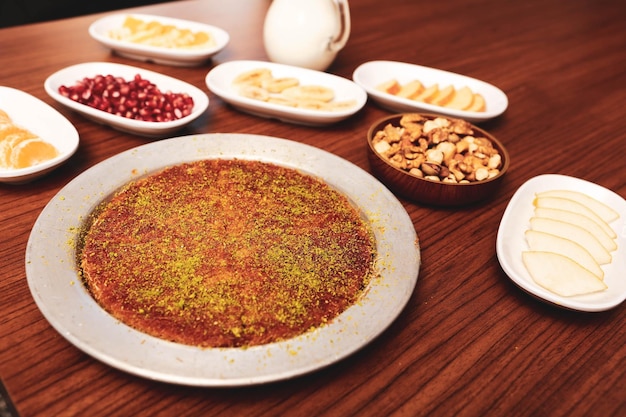 Postre turco kunefe kunafa kadayif con polvo de pistacho y queso caliente comido un dulce