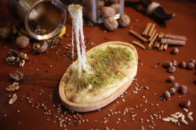 Postre turco kunefe, kunafa, kadayif con polvo de pistacho y queso caliente comido un dulce