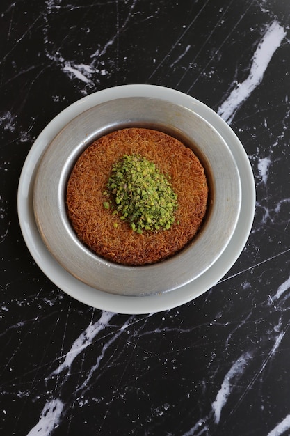 Postre turco kunefe kunafa kadayif con polvo de pistacho y queso caliente comido un dulce