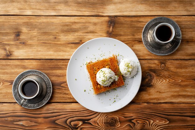 Postre turco kunefe servido con helado sobre fondo de madera