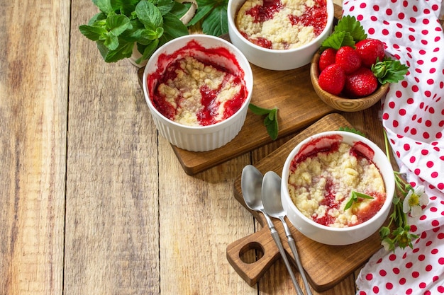 Postre de verano cocina casera Las fresas se desmoronan en un plato para hornear y fresas frescas Copiar espacio