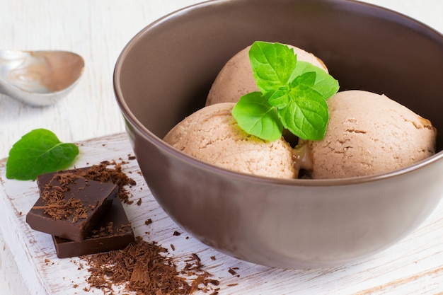 Postre de verano helado de chocolate con hoja de menta en un tazón marrón