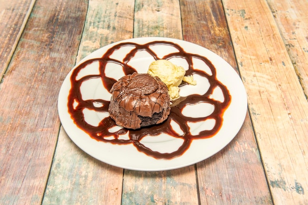 Postre de volcán de chocolate con helado de vainilla en plato blanco