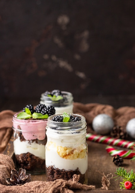 Postres en capas con pastel, crema batida y moras