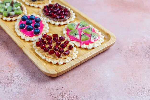 Foto postres caseros con arándanos, rodajas de kiwi y semillas de granada.