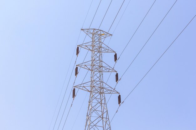 Posts de alto voltaje o torre de alto voltaje en fondo del cielo azul.