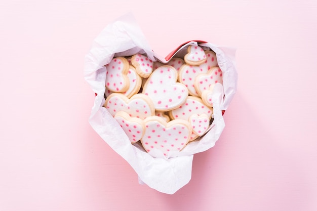 Postura plana. Biscoitos de açúcar em forma de coração decorados com glacê real em caixa de presente.