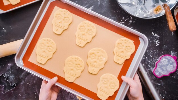 Foto postura plana. biscoitos de caveira de açúcar não cozido na assadeira para o feriado de dia de los muertos.