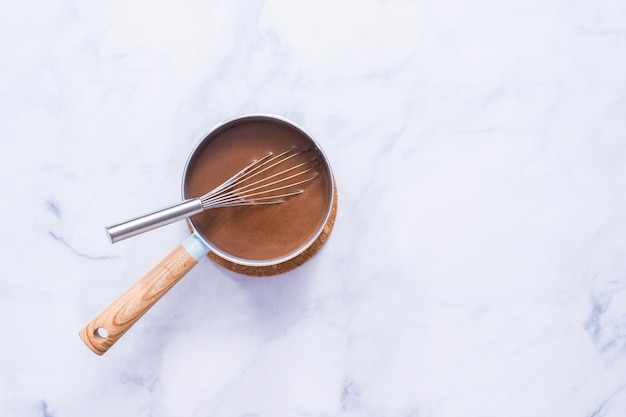 Postura plana. Chocolate quente americano coberto com marshmallow grande em copo de vidro.