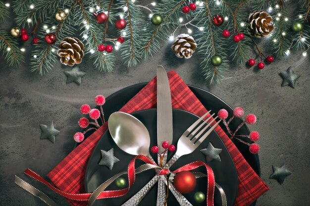 Postura plana com decorações de Natal em verde e vermelho com bagas foscas, bugigangas, pratos e louças