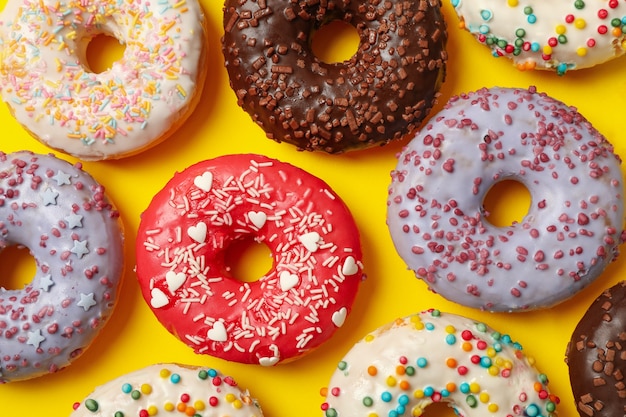 Postura plana com deliciosos donuts em fundo amarelo