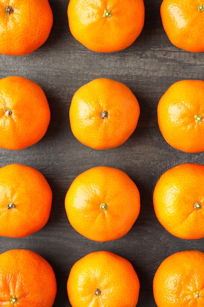 Postura plana com saborosas tangerinas na mesa de madeira texturizada