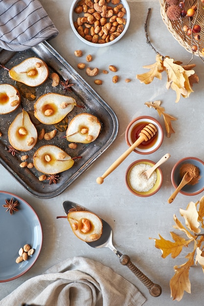 Postura plana com uma bandeja de peras assadas com nozes caramelizadas