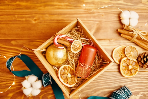 Postura plana da caixa de presente de Natal e decorações na mesa de madeira ano novo atmosfera candy cane candl ...