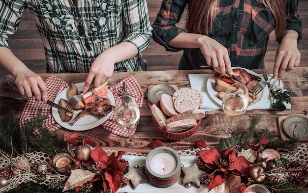 Postura plana de amigos mãos comendo e bebendo juntos. Vista superior das pessoas, festa, reunião, comemorando juntos na mesa rústica de madeira