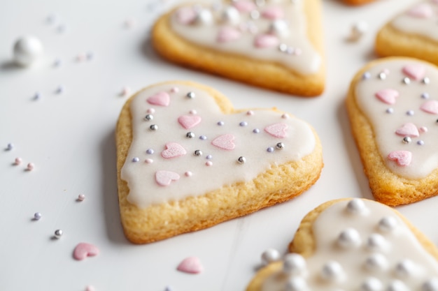 Postura plana de corações cookies com glacê e decorado para o dia dos namorados, fundo branco. Conceito de dia dos namorados.