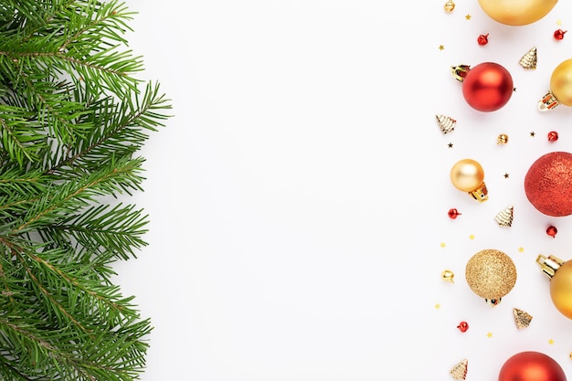 Foto postura plana de natal com galhos de árvores de abeto, enfeites e decorações de natal em fundo branco.