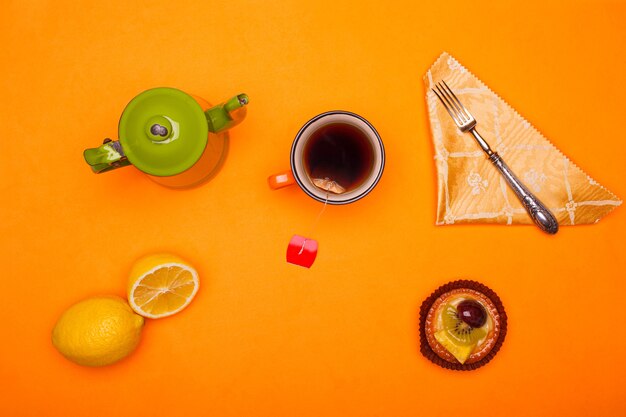 Postura plana de pequeno-almoço rural. Vista superior de uma xícara de chá vintage e uma xícara de chá com limão e massa
