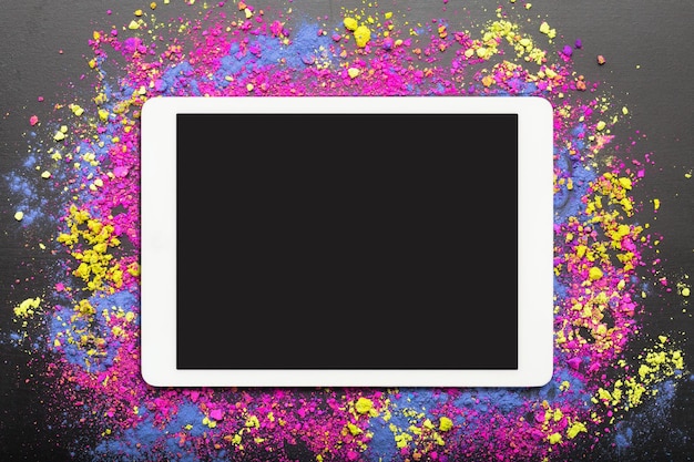 Postura plana de touchpad com tela em branco com pó cosmético colorido em fundo preto