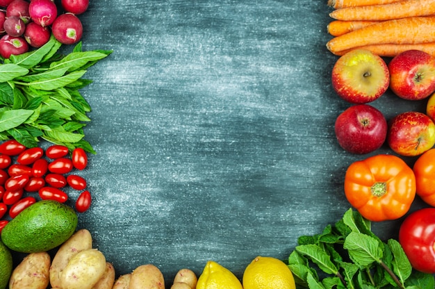 Postura plana de vegetais crus multicoloridos em um fundo preto, quadro de comida. Produtos locais para uma cozinha saudável. Frutas e vegetais orgânicos para a vegetação. Vista do topo. Copie o espaço.