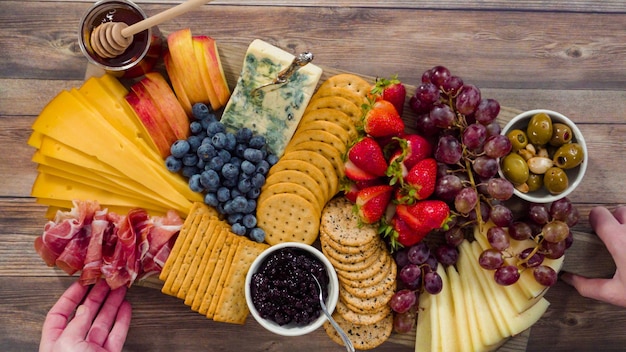 Postura plana. disposição de queijos gourmet, crakers e frutas em uma tábua para uma grande tábua de queijos.