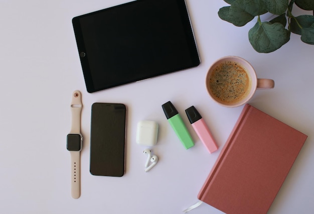 postura plana do espaço de trabalho com tablet, notebook, telefone, smartwatch, fones de ouvido, café, donut