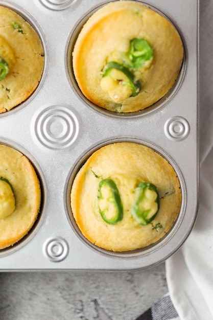 Postura plana. Muffins de pão de milho recém-assados com pimenta jalapeno picante na panela de muffin.