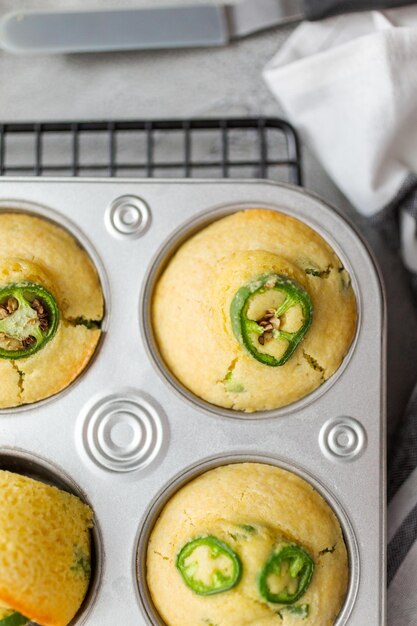 Postura plana. Muffins de pão de milho recém-assados com pimenta jalapeno picante na panela de muffin.