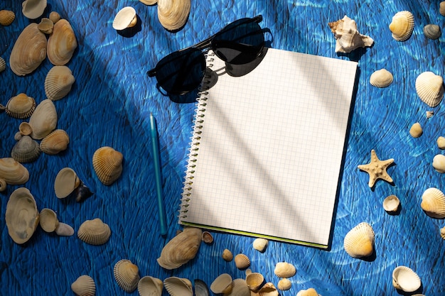 Postura plana no espaço da cópia do caderno em branco de fundo azul. conceito de planos de verão