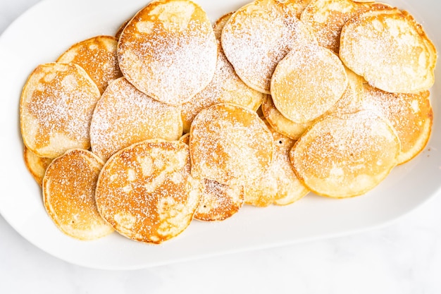 Postura plana. Panquecas feitas na hora em uma base de kefir decorada com açúcar de confeiteiro.