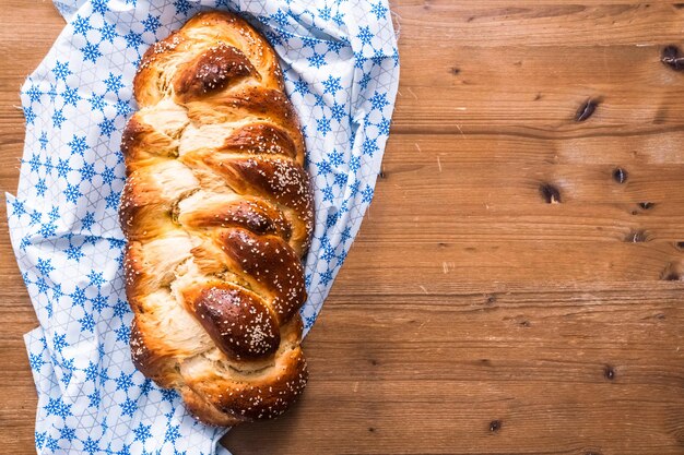 Postura plana. Pão de shalah recém-assado com sementes de gergelim e papoula.