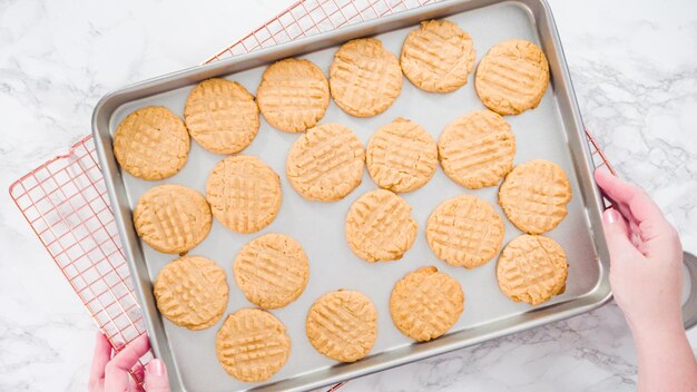 Postura plana. Passo a passo. Biscoitos de manteiga de amendoim recém-assados na assadeira.