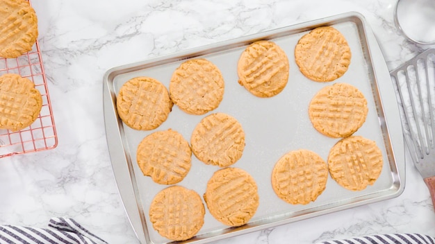 Postura plana. Passo a passo. Biscoitos de manteiga de amendoim recém-assados na assadeira.