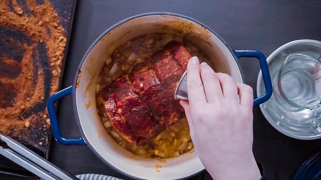 Postura plana. Passo a passo. Cozinhar assado de porco desossado em forno holandês de ferro fundido.