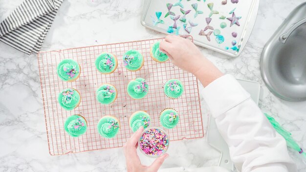 Postura plana. passo a passo. decorando cupcakes de baunilha de sereia com granulado e caudas de sereia de chocolate.