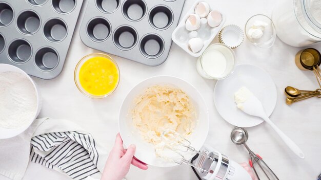 Postura plana. Passo a passo. Misturando a massa para assar cupcakes de baunilha com cobertura de creme de manteiga.