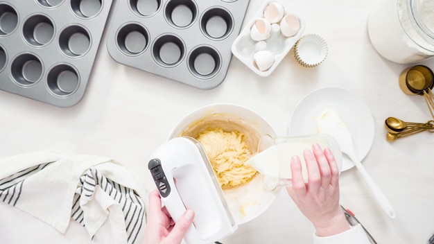 Postura plana. Passo a passo. Misturando a massa para assar cupcakes de baunilha com cobertura de creme de manteiga.