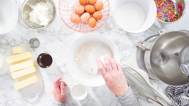 Postura plana. Passo a passo. Misturar ingredientes na batedeira de cozinha em pé para assar bolo de funfetti.