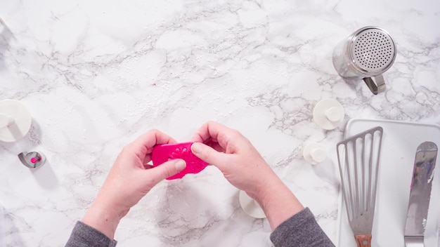 Postura plana. Passo a passo. Rolando nosso fondant rosa em um balcão de mármore.