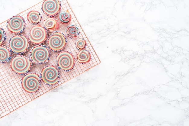 Postura plana. Resfriando biscoitos de açúcar de cata-vento vermelhos, brancos e azuis em um rack de resfriamento. Sobremesa para a celebração do 4 de julho.