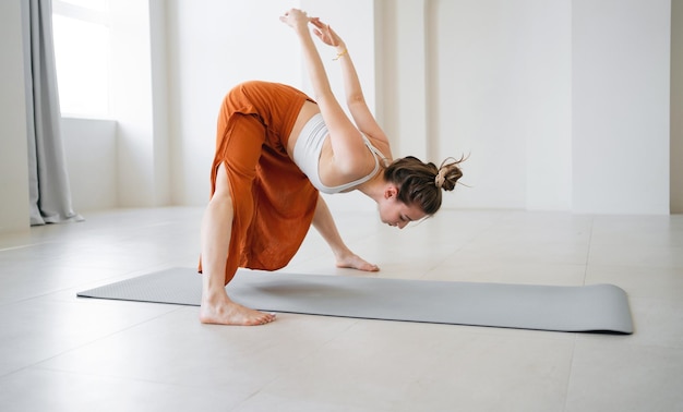 Postura de yoga para la flexibilidad del entrenamiento de ropa deportiva de mujer corporal en el equilibrio de fitness del club