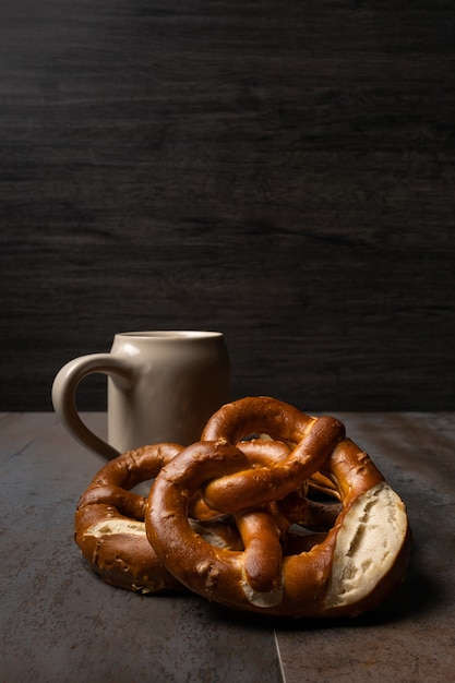 pote de cerveja e pretzels oktoberfest de fundo escuro e mesa de textura