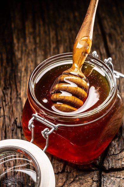 Pote de mel com concha na mesa de madeira - closeup.