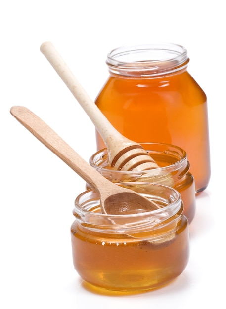 Pote de vidro cheio de mel isolado no branco