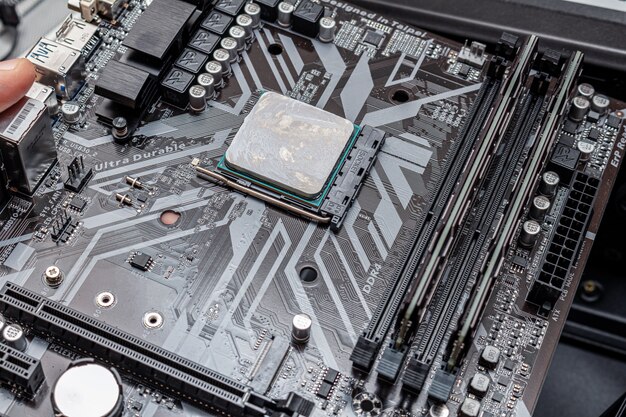 Potente CPU con grasa térmica aplicada en una computadora personal. El proceso de actualización de mantenimiento de la computadora que instala el ensamblaje de la PC en un servicio.