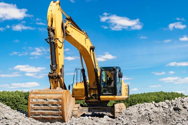 Potente excavadora industrial en una cantera contra un cielo azul nublado Cargando piedra triturada y suelo con una excavadora Equipos de movimiento de tierras y movimiento de tierras